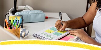 Ein Schüler macht sich Notizen auf Post-it® Notes
