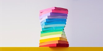 Ein Stapel farbenfroher Post-it® Notes, die in einem Turm angeordnet sind und eine Vielzahl von Post-it® Notes in leuchtenden Farben
