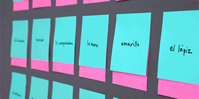Eine Wand, die mit Post-it® Super Sticky Notes mit spanischen Vokabeln bedeckt ist, die zum Sprachenlernen verwendet werden

